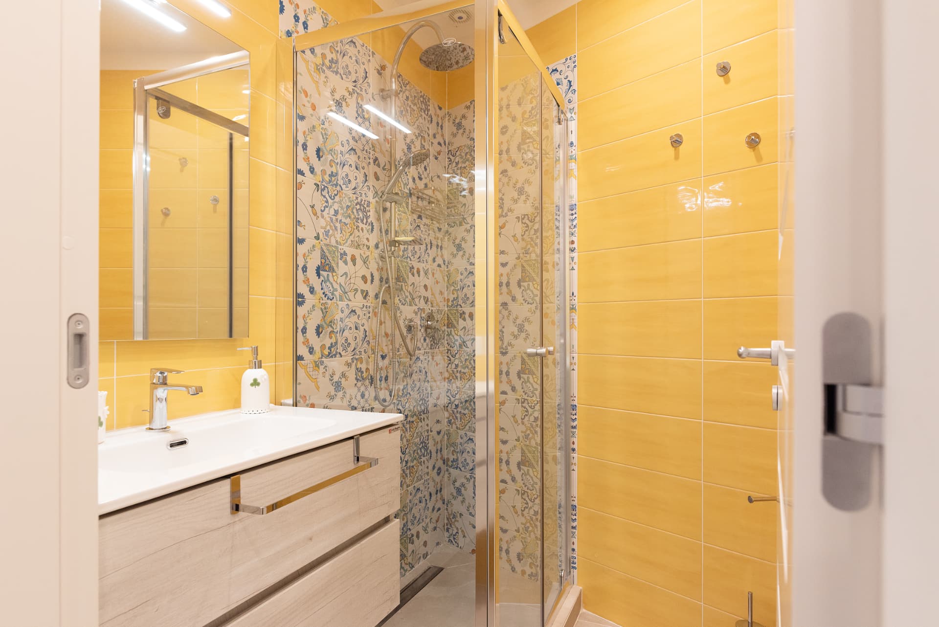 Primo bagno con doccia e maioliche gialle in stile napoletano, appartamento L'Orchidea al Museo a Napoli